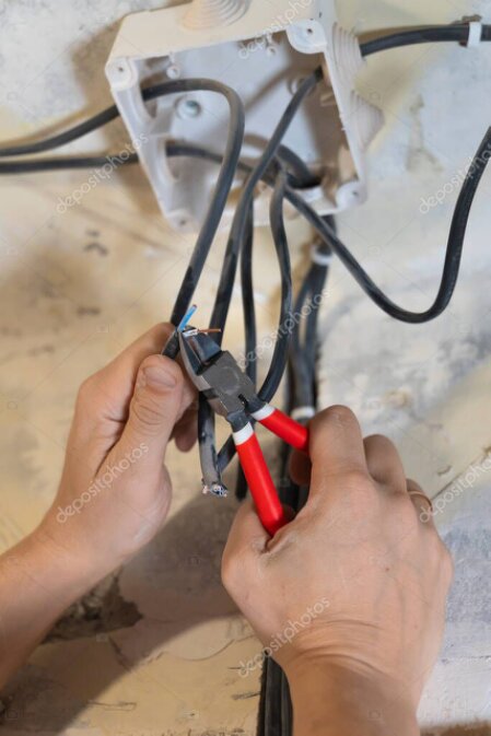 Elektrik panosu önünde çalışan elektrik ustası